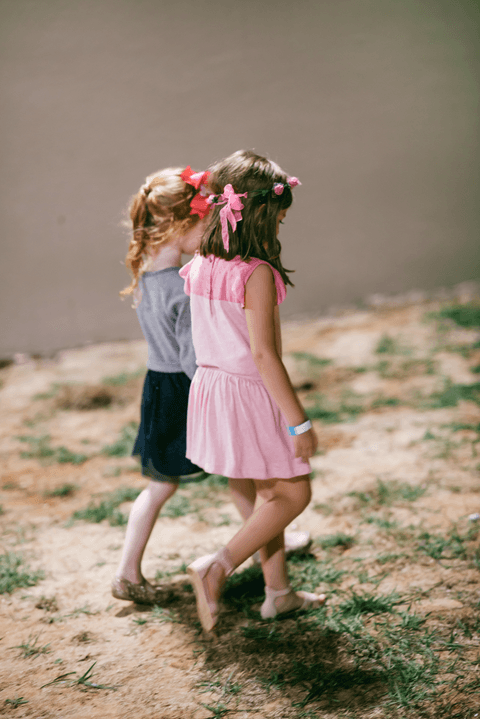 Duas amiguinhas caminham juntas para brincar'