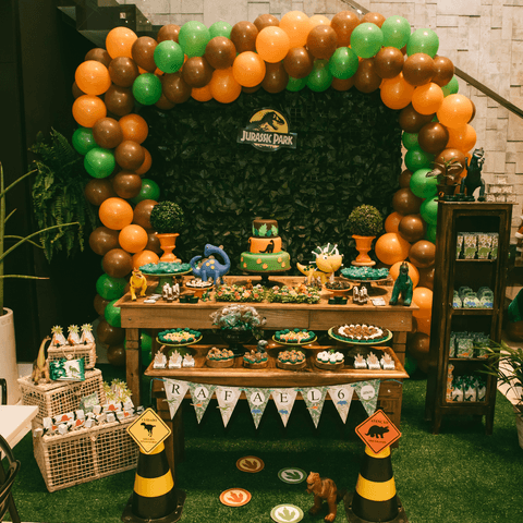 Balões contornando a mesa de bolo com tema dinossauros bem diertido'