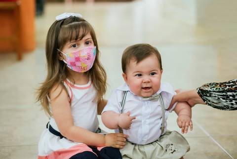 Irmãozinhos brincando enquanto são fotografados'