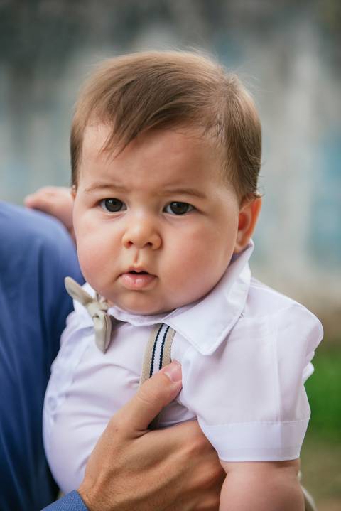Bebê no colo tirando fotos do batizado'