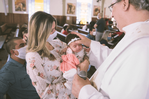 Padre Camilo  em passagem a SJC faz sinal da cruz em cerimônia de batismo'