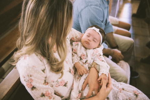 Linda foto de batismo com mãe abraçamdo bebê
'