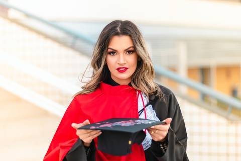 Foto com o capelo e faixa vermelha do curso de direito'