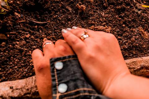 Fotos das mãos do casal em um ensaio pré wedding. As mãos estão sobre uma jardineira de madeira.'