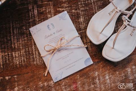 convite de casamento e sandália da noiva'