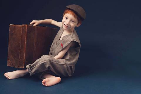 menino ruivo com mala antiga'