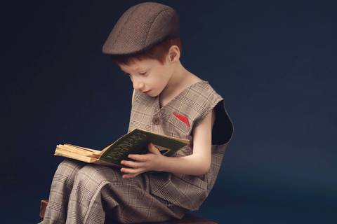 menino com boina sentado a ler'