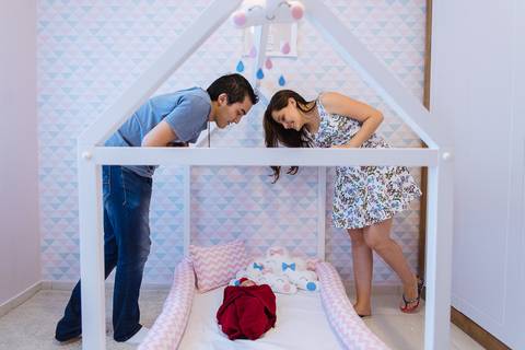 Família sorrindo na caminha da bebe'