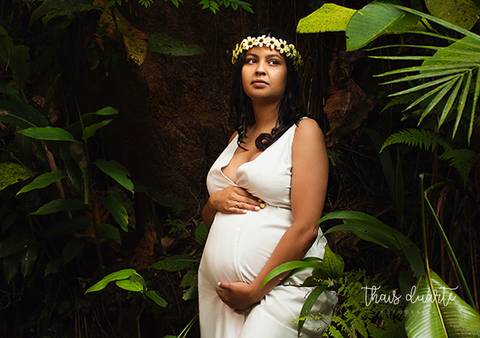 Fotografia de gestante de vestido branco e coroa de flores segurando a barrigapor Thais Duarte Fotografia'