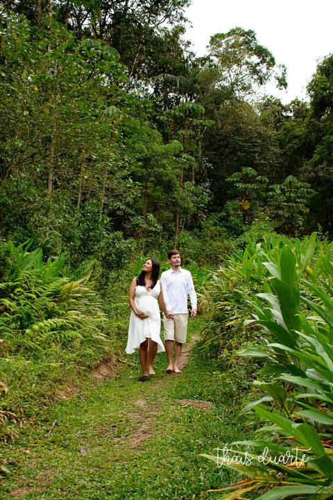 Fotografia de gestante e marido em meio a trilha na natureza pela fotógrafa Thais Duarte'