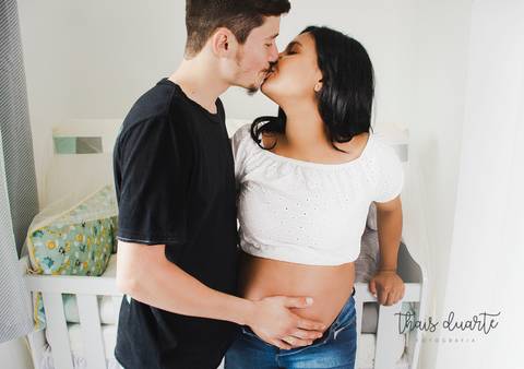Fotografia de casal se beijando no quartinho do bebê foto por Thais Duarte'