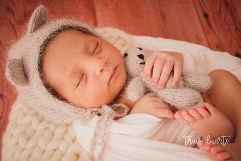 Fotografia de recém nascido abraçado com ursinho'