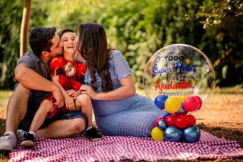 pais dando beijo no filho e mãe gestante'