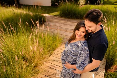 fotos do ensaio gestante com o casal em ponte de madeira com os dois juntos'