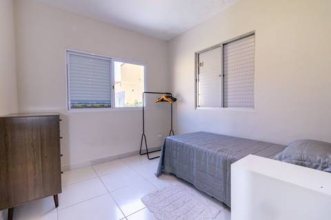 Fotografia profissional de uma casa no bairro Jardim Samambaia, em Praia Grande, SP, pelo fotógrafo profissional de imóveis Fernando Freire, foto para anúncio no Airbnb e Booking. Ambiente do quarto com mobília.'