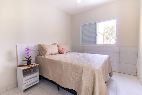 Fotografia profissional de uma casa no bairro Jardim Samambaia, em Praia Grande, SP, pelo fotógrafo profissional de imóveis Fernando Freire, foto para anúncio no Airbnb e Booking. Ambiente do quarto completo e mobiliado.'