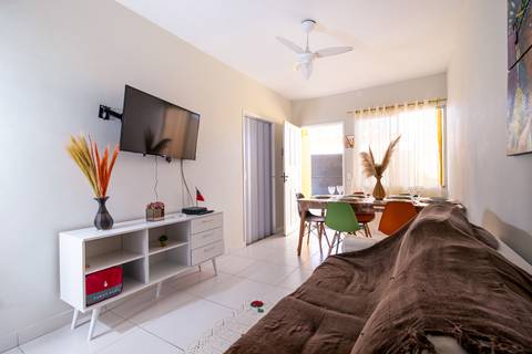 Fotografia profissional de uma casa no bairro Jardim Samambaia, em Praia Grande, SP, pelo fotógrafo profissional de imóveis Fernando Freire, foto para anúncio no Airbnb e Booking. Ambiente da sala completa e mobiliada.'