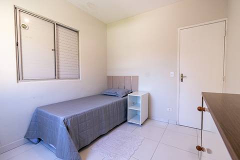 Fotografia profissional de uma casa no bairro Jardim Samambaia, em Praia Grande, SP, pelo fotógrafo profissional de imóveis Fernando Freire, foto para anúncio no Airbnb e Booking. Ambiente do quarto com mobília.'