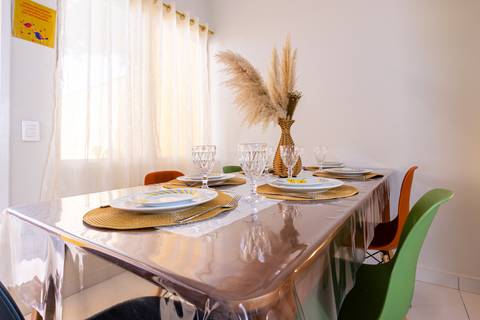 Fotografia profissional de uma casa no bairro Jardim Samambaia, em Praia Grande, SP, pelo fotógrafo profissional de imóveis Fernando Freire, foto para anúncio no Airbnb e Booking. Ambiente da sala completa e mobiliada.'