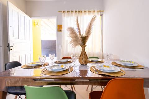 Fotografia profissional de uma casa no bairro Jardim Samambaia, em Praia Grande, SP, pelo fotógrafo profissional de imóveis Fernando Freire, foto para anúncio no Airbnb e Booking. Ambiente da sala completa e mobiliada.'