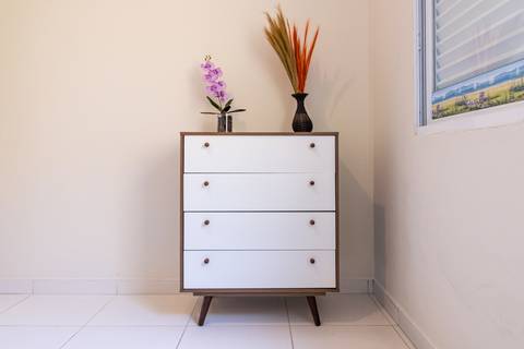 Fotografia profissional de uma casa no bairro Jardim Samambaia, em Praia Grande, SP, pelo fotógrafo profissional de imóveis Fernando Freire, foto para anúncio no Airbnb e Booking. Ambiente do quarto com mobília.'