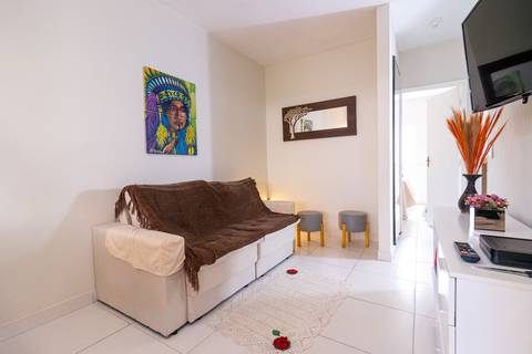 Fotografia profissional de uma casa no bairro Jardim Samambaia, em Praia Grande, SP, pelo fotógrafo profissional de imóveis Fernando Freire, foto para anúncio no Airbnb e Booking. Ambiente da sala completa e mobiliada.'