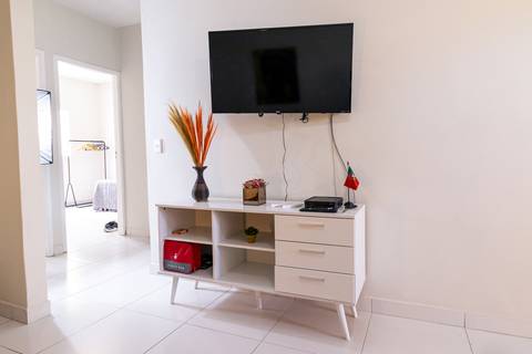 Fotografia profissional de uma casa no bairro Jardim Samambaia, em Praia Grande, SP, pelo fotógrafo profissional de imóveis Fernando Freire, foto para anúncio no Airbnb e Booking. Ambiente da sala completa e mobiliada.'