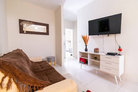 Fotografia profissional de uma casa no bairro Jardim Samambaia, em Praia Grande, SP, pelo fotógrafo profissional de imóveis Fernando Freire, foto para anúncio no Airbnb e Booking. Ambiente da sala completa e mobiliada.'