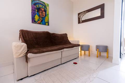 Fotografia profissional de uma casa no bairro Jardim Samambaia, em Praia Grande, SP, pelo fotógrafo profissional de imóveis Fernando Freire, foto para anúncio no Airbnb e Booking. Ambiente da sala completa e mobiliada.'