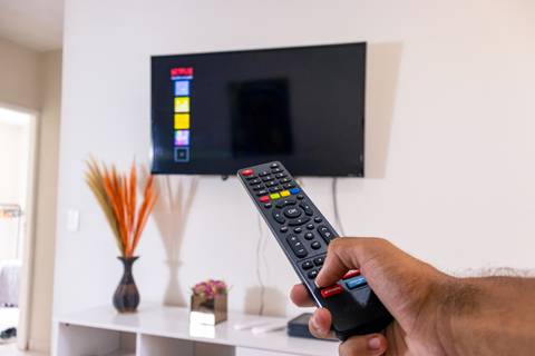 Fotografia profissional de uma casa no bairro Jardim Samambaia, em Praia Grande, SP, pelo fotógrafo profissional de imóveis Fernando Freire, foto para anúncio no Airbnb e Booking. Ambiente da sala completa e mobiliada.'