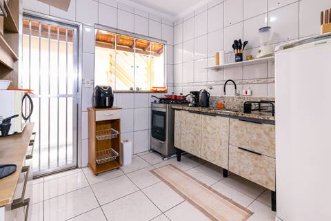 Fotografia profissional de uma casa no bairro Jardim Samambaia, em Praia Grande, SP, pelo fotógrafo profissional de imóveis Fernando Freire, foto para anúncio no Airbnb e Booking. Ambiente da cozinha completa e mobiliada.'