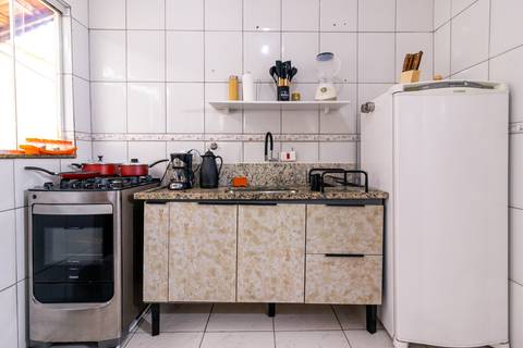 Fotografia profissional de uma casa no bairro Jardim Samambaia, em Praia Grande, SP, pelo fotógrafo profissional de imóveis Fernando Freire, foto para anúncio no Airbnb e Booking. Ambiente da cozinha completa e mobiliada.'