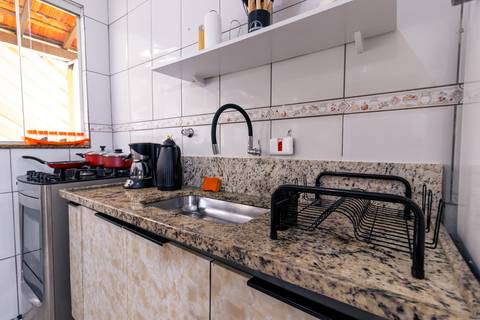 Fotografia profissional de uma casa no bairro Jardim Samambaia, em Praia Grande, SP, pelo fotógrafo profissional de imóveis Fernando Freire, foto para anúncio no Airbnb e Booking. Ambiente da cozinha completa e mobiliada.'