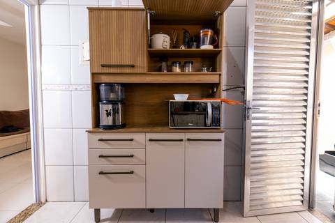 Fotografia profissional de uma casa no bairro Jardim Samambaia, em Praia Grande, SP, pelo fotógrafo profissional de imóveis Fernando Freire, foto para anúncio no Airbnb e Booking. Ambiente da cozinha completa e mobiliada.'