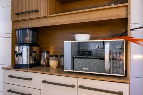 Fotografia profissional de uma casa no bairro Jardim Samambaia, em Praia Grande, SP, pelo fotógrafo profissional de imóveis Fernando Freire, foto para anúncio no Airbnb e Booking. Ambiente da cozinha completa e mobiliada.'