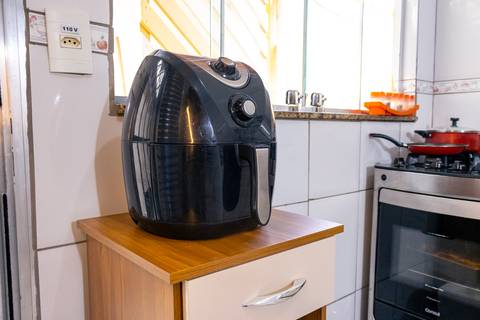 Fotografia profissional de uma casa no bairro Jardim Samambaia, em Praia Grande, SP, pelo fotógrafo profissional de imóveis Fernando Freire, foto para anúncio no Airbnb e Booking. Ambiente da cozinha completa e mobiliada.'