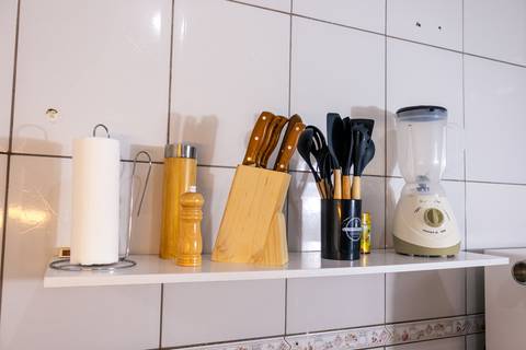 Fotografia profissional de uma casa no bairro Jardim Samambaia, em Praia Grande, SP, pelo fotógrafo profissional de imóveis Fernando Freire, foto para anúncio no Airbnb e Booking. Ambiente da cozinha completa e mobiliada.'