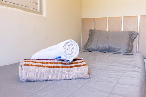 Fotografia profissional de uma casa no bairro Jardim Samambaia, em Praia Grande, SP, pelo fotógrafo profissional de imóveis Fernando Freire, foto para anúncio no Airbnb e Booking. Ambiente do quarto com mobília.'