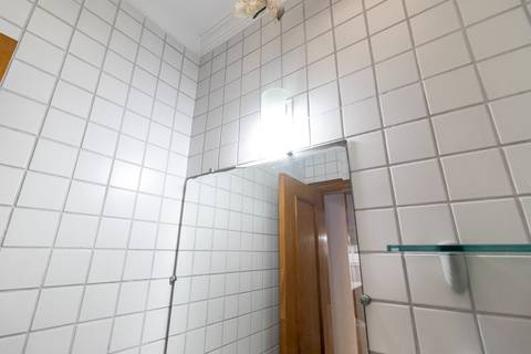 Fotografia profissional de uma cobertura no bairro Canto do Forte, em Praia Grande, SP, pelo fotógrafo profissional de imóveis Fernando Freire, foto para anúncio de apartamento no Airbnb e QuintoAndar. Ambiente da área de serviço com quarto e banheiro.'