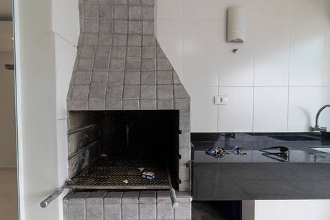 Fotografia profissional de uma cobertura no bairro Canto do Forte, em Praia Grande, SP, pelo fotógrafo profissional de imóveis Fernando Freire, foto para anúncio de apartamento no Airbnb e QuintoAndar. Ambiente da varanda com churrasqueira e piscina.'