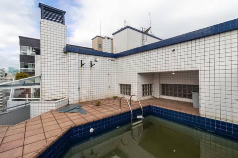 Fotografia profissional de uma cobertura no bairro Canto do Forte, em Praia Grande, SP, pelo fotógrafo profissional de imóveis Fernando Freire, foto para anúncio de apartamento no Airbnb e QuintoAndar. Ambiente da varanda com churrasqueira e piscina.'