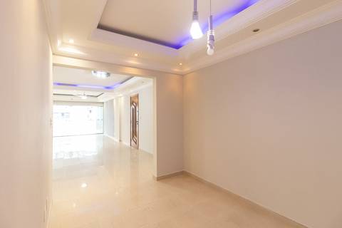 Fotografia profissional de uma cobertura no bairro Canto do Forte, em Praia Grande, SP, pelo fotógrafo profissional de imóveis Fernando Freire, foto para anúncio de apartamento no Airbnb e QuintoAndar. Ambiente da sala com acesso aos dormitorios.'