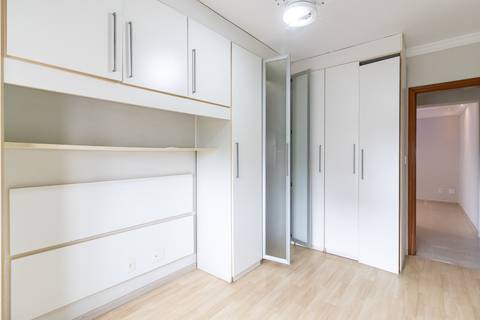 Fotografia profissional de uma cobertura no bairro Canto do Forte, em Praia Grande, SP, pelo fotógrafo profissional de imóveis Fernando Freire, foto para anúncio de apartamento no Airbnb e QuintoAndar. Ambiente da primeira suíte com armário planejado.'