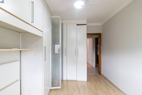 Fotografia profissional de uma cobertura no bairro Canto do Forte, em Praia Grande, SP, pelo fotógrafo profissional de imóveis Fernando Freire, foto para anúncio de apartamento no Airbnb e QuintoAndar. Ambiente da primeira suíte com armário planejado.'