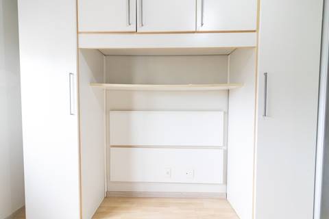 Fotografia profissional de uma cobertura no bairro Canto do Forte, em Praia Grande, SP, pelo fotógrafo profissional de imóveis Fernando Freire, foto para anúncio de apartamento no Airbnb e QuintoAndar. Ambiente da primeira suíte com armário planejado.'