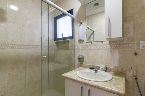 Fotografia profissional de uma cobertura no bairro Canto do Forte, em Praia Grande, SP, pelo fotógrafo profissional de imóveis Fernando Freire, foto para anúncio de apartamento no Airbnb e QuintoAndar. Ambiente do banheiro  completo da primeira suíte.'