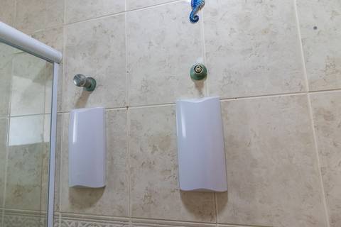 Fotografia profissional de uma cobertura no bairro Canto do Forte, em Praia Grande, SP, pelo fotógrafo profissional de imóveis Fernando Freire, foto para anúncio de apartamento no Airbnb e QuintoAndar. Ambiente do banheiro completo da segunda suíte.'