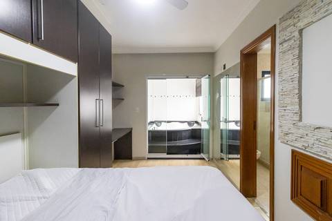 Fotografia profissional de uma cobertura no bairro Canto do Forte, em Praia Grande, SP, pelo fotógrafo profissional de imóveis Fernando Freire, foto para anúncio de apartamento no Airbnb e QuintoAndar. Ambiente da terceira suíte com banheira e armário.'