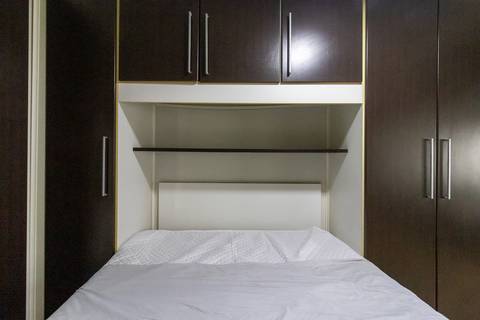 Fotografia profissional de uma cobertura no bairro Canto do Forte, em Praia Grande, SP, pelo fotógrafo profissional de imóveis Fernando Freire, foto para anúncio de apartamento no Airbnb e QuintoAndar. Ambiente da terceira suíte com banheira e armário.'