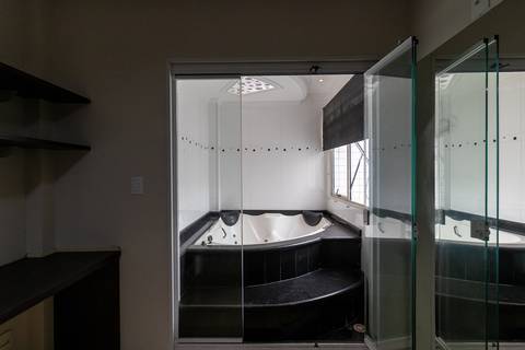 Fotografia profissional de uma cobertura no bairro Canto do Forte, em Praia Grande, SP, pelo fotógrafo profissional de imóveis Fernando Freire, foto para anúncio de apartamento no Airbnb e QuintoAndar. Ambiente da terceira suíte com banheira e armário.'